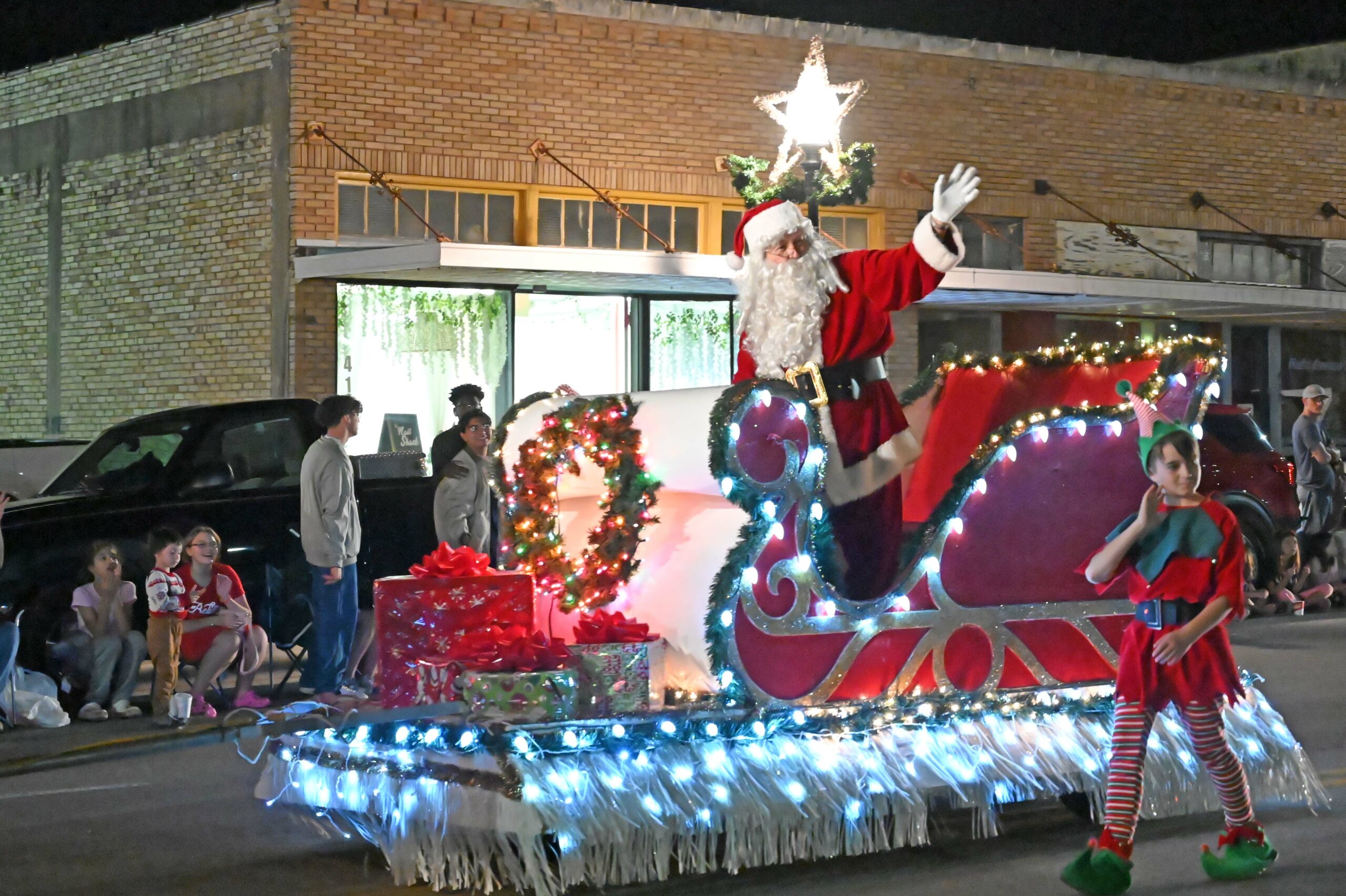 Santa waves at the audience in his sleigh during the 2021 annual Parade of Lights.